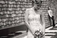 Braut mit Brautstrauß, Bräutigam im Hintergrund